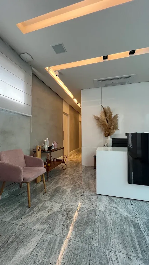 Recepção da clínica com poltrona e iluminação indireta